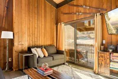 a living room with a couch and a large window at NEW Summit Lookout in Big Bear Lake