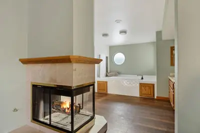 a living room with a fireplace and a bathroom at Roaring Lion Lakefront Lodge in Big Bear Lake