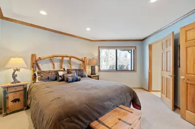 a bedroom with a large bed and a window at Roaring Lion Lakefront Lodge in Big Bear Lake