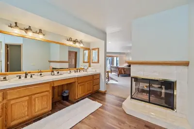 a bathroom with a fireplace and a large mirror at Roaring Lion Lakefront Lodge in Big Bear Lake
