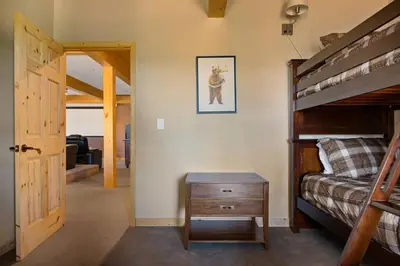 a bedroom with a bunk bed and a wooden table at Sky High Mountain Lodge Lake View in Big Bear Lake