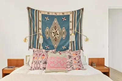 a bed with a large head board with pillows on it at Mountain Top Modern Lakefront in Sunset Magazine in Big Bear Lake