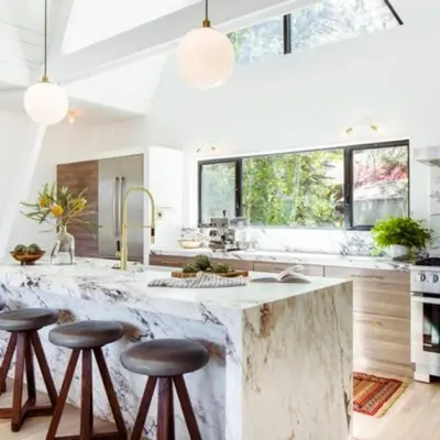 a kitchen with a large marble counter top and stools at Mountain Top Modern Lakefront in Sunset Magazine in Big Bear Lake