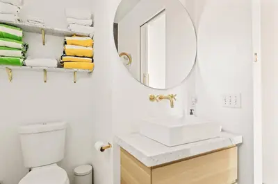a white bathroom with a sink and a mirror at Mountain Top Modern Lakefront in Sunset Magazine in Big Bear Lake