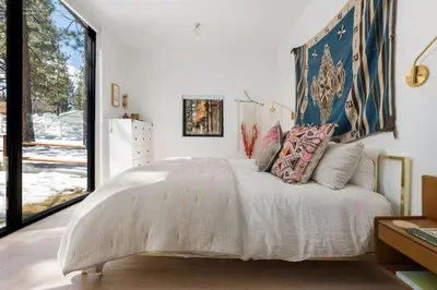a bedroom with a large bed with a large window at Mountain Top Modern Lakefront in Sunset Magazine in Big Bear Lake