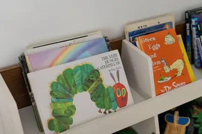 a shelf with books and a caterpillar and a book at Mountain Top Modern Lakefront in Sunset Magazine in Big Bear Lake