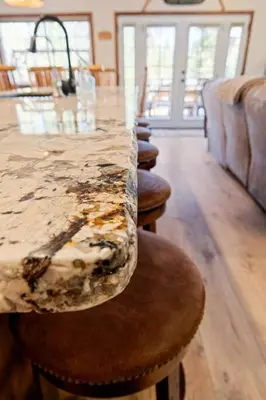 a kitchen with a marble counter top and stools at Snowcrest Lodge in Exclusive Fox Farm in Big Bear Lake