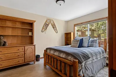 a bedroom with a bed with a dresser and a window at Snowcrest Lodge in Exclusive Fox Farm in Big Bear Lake