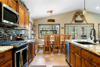 a kitchen with wooden cabinets and a counter top at Snowcrest Lodge in Exclusive Fox Farm in Big Bear Lake
