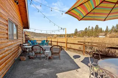 a patio with a table and chairs and an umbrella at Honeybee by the Bay in Big Bear Lake in Big Bear Lake