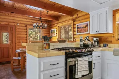a kitchen with white cabinets and a stove at Bear Kub Kabin in Big Bear Lake