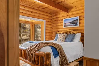 a bedroom with a bed in a log cabin at Bear Kub Kabin in Big Bear Lake