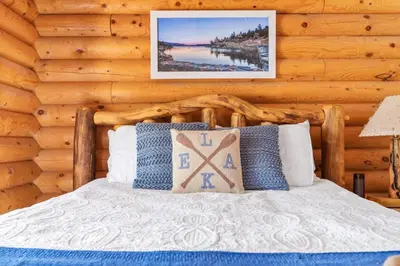 a bedroom with a bed in a log cabin at Bear Kub Kabin in Big Bear Lake