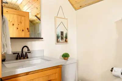a white bathroom with a sink and a mirror at Zen Mountain Retreat in Big Bear Lake