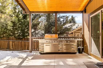 a patio with an outdoor kitchen on a house at Zen Mountain Retreat in Big Bear Lake