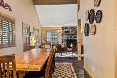 a dining room with a wooden table and a fireplace at The Great Escape in Big Bear Lake