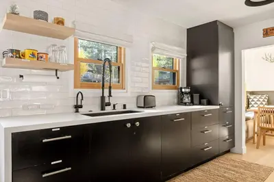 a kitchen with black cabinets and a sink at Lakefront View Stunner in Big Bear Lake