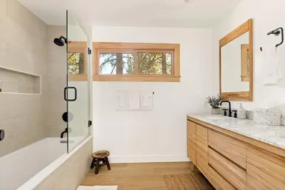 a bathroom with a tub and a sink and a mirror at Lakefront View Stunner in Big Bear Lake