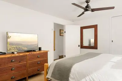 a bedroom with a bed and a flat screen tv on a dresser at Lakefront View Stunner in Big Bear Lake