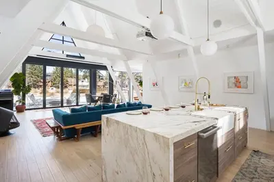a kitchen and living room with a table and a couch at Lakefront Modern A Frame in Big Bear Lake