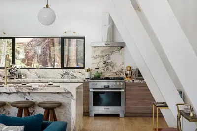 a kitchen with a stove and a counter with stools at Lakefront Modern A Frame in Big Bear Lake