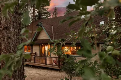 a house with a porch in the woods at Knoll Lake Cabin in Big Bear Lake in Big Bear Lake