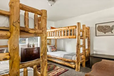 a bedroom with two bunk beds and a desk at Fawnskin Forest Haven in Fawnskin