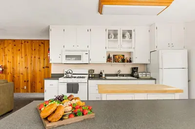 a kitchen with white cabinets and a tray of food at Fawnskin Forest Haven in Fawnskin