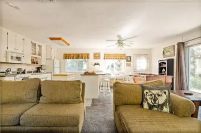 a living room with two couches and a kitchen at Fawnskin Forest Haven in Fawnskin