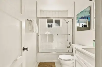a white bathroom with a toilet and a sink at Fawnskin Forest Haven in Fawnskin
