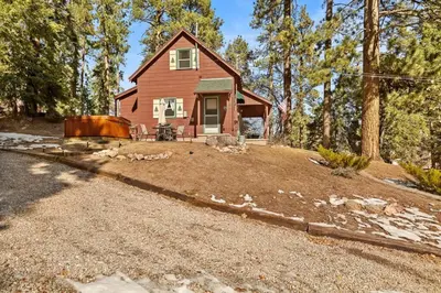 a small red house in the middle of a yard at Tree Top Ranch in Big Bear Lake