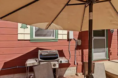 a table with an umbrella in front of a house at Tree Top Ranch in Big Bear Lake