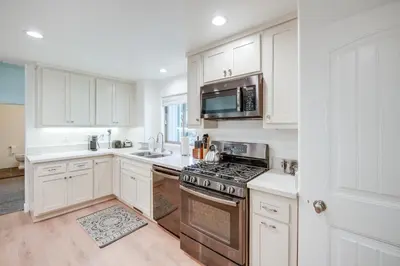 a kitchen with white cabinets and a stove top oven at Serene Pine Mountain Club Home with Pool Access! in Pine Mountain Club