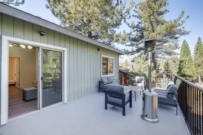 a patio with chairs and tables on a deck at Serene Pine Mountain Club Home with Pool Access! in Pine Mountain Club