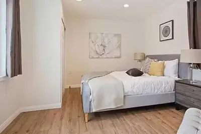 a bedroom with a bed and a dresser with a lamp at Spacious 3Bdr Home close to Manhattan Beach in Lawndale