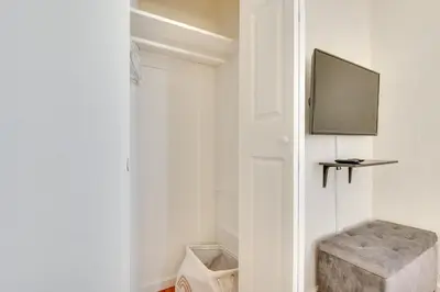 a white hallway with a stool and a television at North Hollywood Getaway 14 Mi to Downtown! in North Hollywood