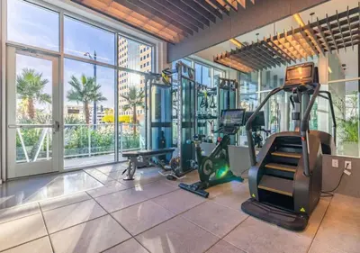a gym with exercise equipment and a large window at @ Marbella Lane - Grand 2BR w/ Beach & Ocean Views in Long Beach