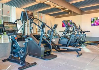 a row of treadmills and ellipticals in a gym at @ Marbella Lane - Grand 2BR w/ Beach & Ocean Views in Long Beach