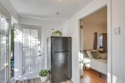 a kitchen with a refrigerator and a living room at Los Angeles Apartment with Patio, 4 Mi to Downtown! in Los Angeles