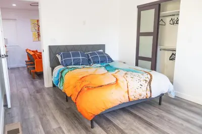 a bedroom with a bed with an orange blanket and blue pillows at Beautiful hillside gateway in Los Angeles