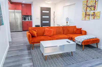 a living room with an orange couch and a table at Beautiful hillside gateway in Los Angeles