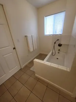 a white bathroom with a tub and a window at 4 Bedrooms & 2.5 Bathrooms in LA in Los Angeles