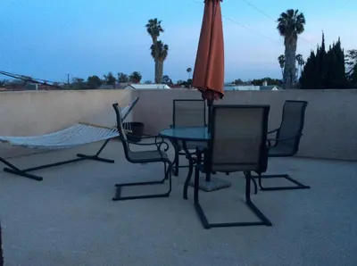 a patio with a table and chairs and an umbrella at 4 Bedrooms & 2.5 Bathrooms in LA in Los Angeles