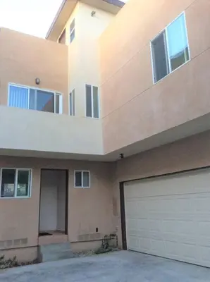 a house with a garage door and a building at 4 Bedrooms & 2.5 Bathrooms in LA in Los Angeles