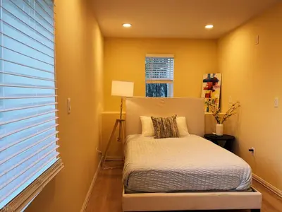 a bed in a room with yellow walls and a window at Hollywood Hills Haven-Guest House in Los Angeles