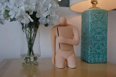 a doll sitting on a table next to a vase of flowers at Skyline Serenity Luxe Suite-Private Room in Los Angeles