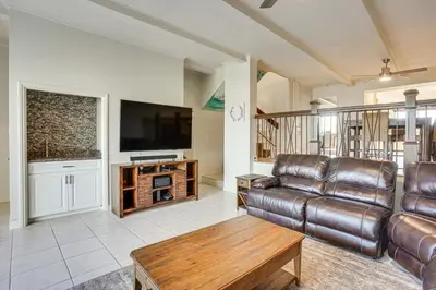 a living room with a leather couch and a flat screen tv at Huntington Beach Condo - Walk to the Ocean! in Huntington Beach