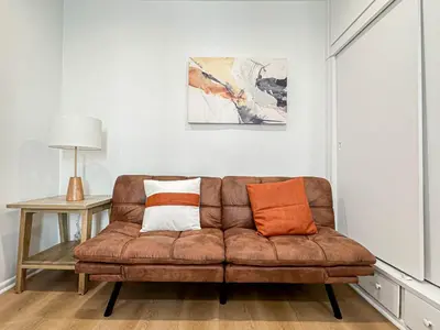 a living room with a brown couch and a table at Modern 2-Bedroom Gem Close to Beverly Hills - DOH2 in Los Angeles