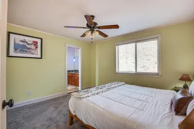 a bedroom with a bed and a ceiling fan at Expansive Mountain Gem Game Room, 3 Mi to Acton in Ravenna