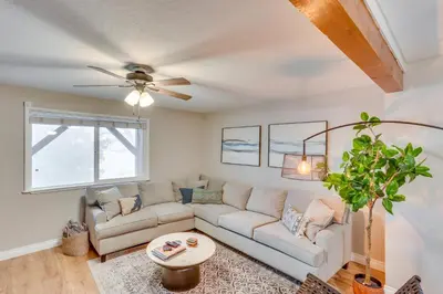 a living room with a couch and a ceiling fan at Mid-Century Mod Cottage, Steps to Lake Gregory! in Crestline